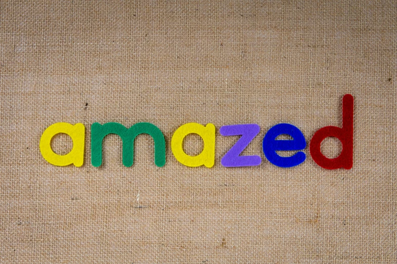 the word amazing spelled in multicolored wooden letters, an album cover, inspired by Amédée Ozenfant, pexels, assamese, grizzled, 3d printed, cloth banners