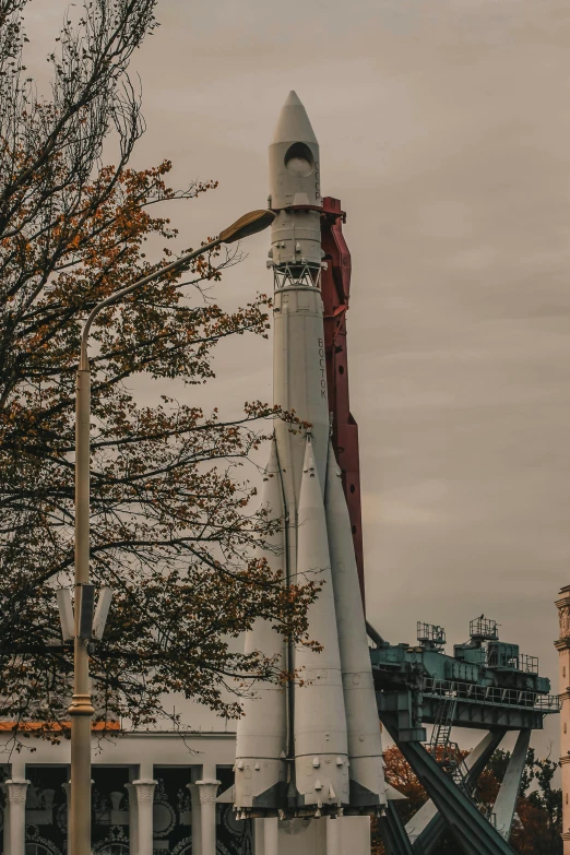 a large white rocket sitting on top of a building, a statue, by Niko Henrichon, unsplash, glasgow, spaceship being repaired, high quality photo, telephoto long distance shot