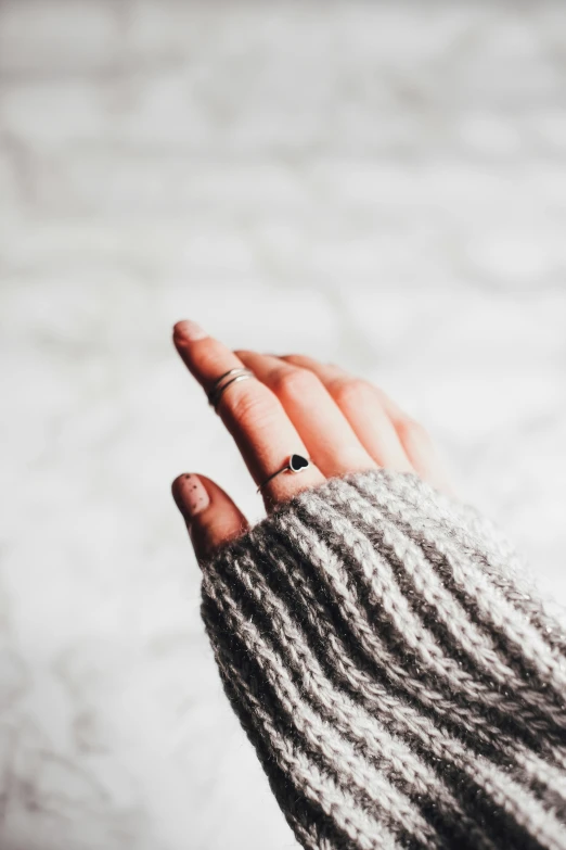 a person wearing a pair of fingerless gloves, a tattoo, trending on pexels, grey sweater, ring, instagram picture, smol