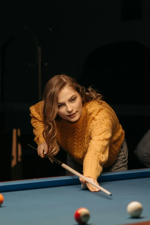 a woman is playing a game of pool, a portrait, trending on pexels, 15081959 21121991 01012000 4k, in a navy blue sweater, promotional image, handsome girl