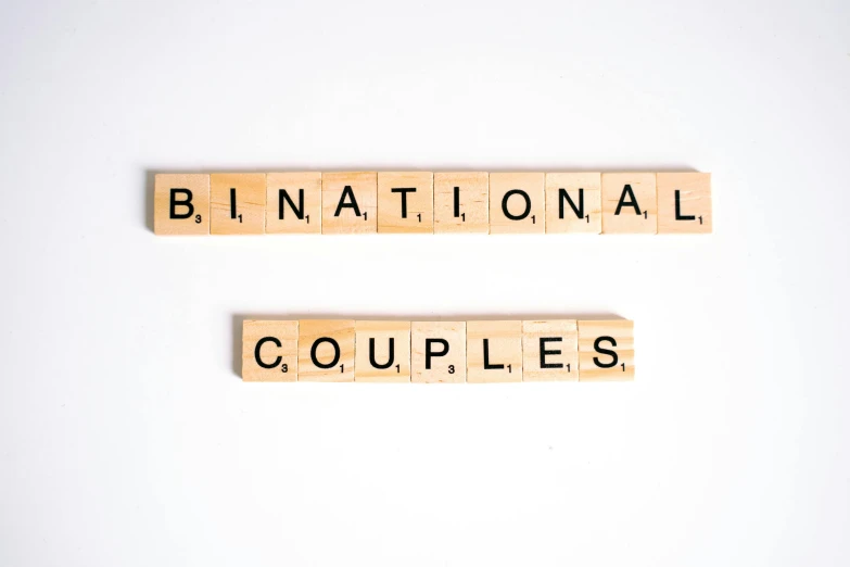 a couple of scrabbles sitting on top of each other, international typographic style, bionics, bilaterally symmetrical, marriage, sitting down casually