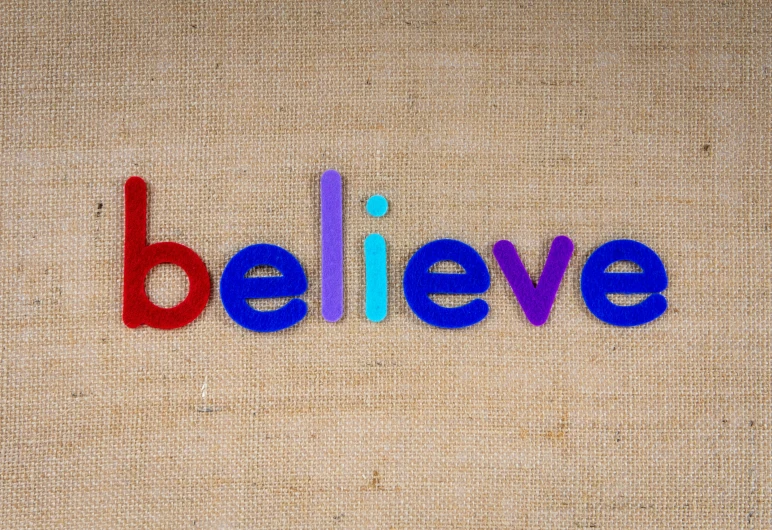 the word believe spelled in colorful plastic letters, a picture, inspired by Henri Bellechose, unsplash, needle felting, atheism god, in the style of john baldessari, amanda clarke