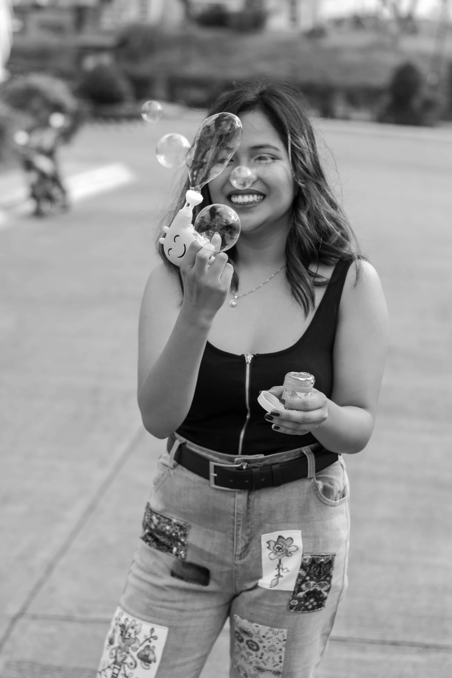 a black and white photo of a woman eating a donut, by Olivia Peguero, holding maracas, [ bubbles, happily smiling at the camera, street pic