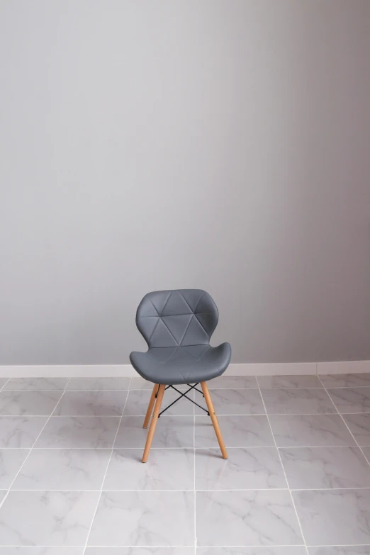 a grey chair sitting on top of a tiled floor, a picture, light grey backdrop, commercial photograph, photoshoot, y