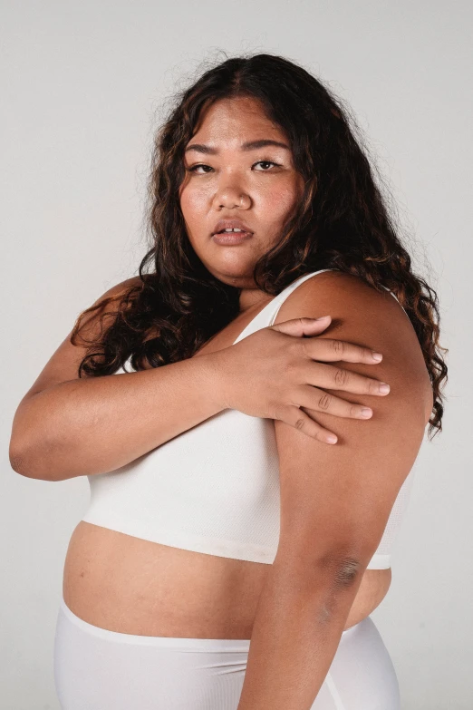 a woman in white underwear posing for a picture, by Matija Jama, trending on pexels, proportionally enormous arms, south east asian with round face, wearing a cropped tops, editorial image