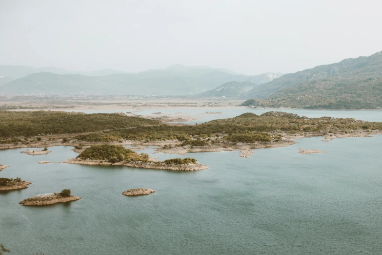 a large body of water surrounded by mountains, by Emma Andijewska, unsplash contest winner, visual art, baotou china, scattered islands, a still of kowloon, zezhou chen