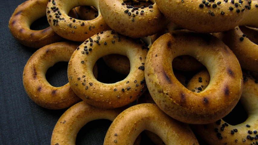 a pile of bagels sitting on top of a table, pexels, hurufiyya, thumbnail, brown holes, middle eastern, golden eal