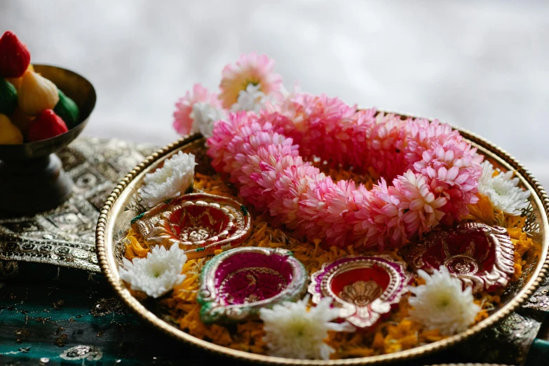 a close up of a plate of food on a table, hurufiyya, flower tiara, hindu stages of meditation, bangles, pink