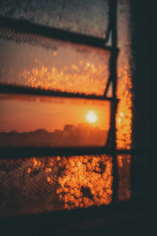 a close up of a window with a sunset in the background, a picture, inspired by Elsa Bleda, happening, orange mist, picture through the screen, during the night, day setting