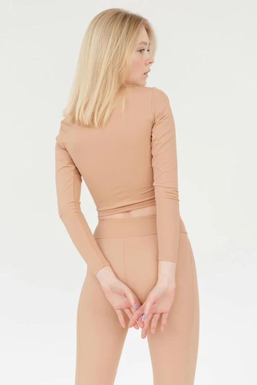 a woman in a nude colored top and leggings, inspired by Vanessa Beecroft, detailed product image, belly button showing, curated collections, detail shot