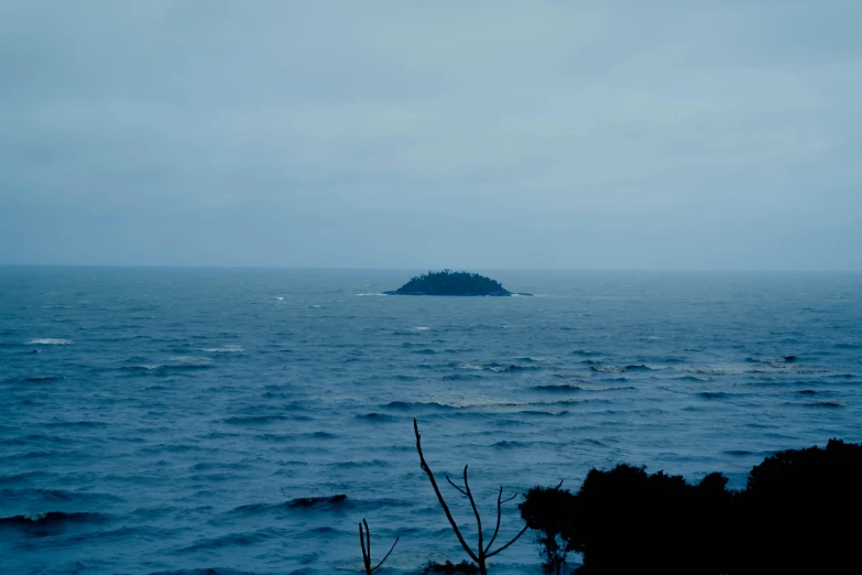 a small island in the middle of the ocean, an album cover, inspired by Elsa Bleda, unsplash, haida gwaii, overcast day, blue, 2 5 6 x 2 5 6 pixels