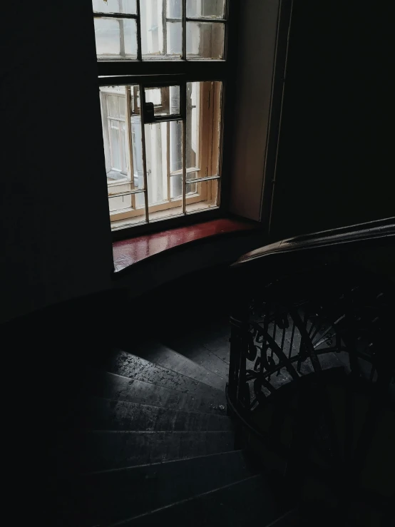 a light shines through a window in a dark room, inspired by Elsa Bleda, unsplash contest winner, stairs to the second floor, dark red and black color palette, instagram story, in a museum room