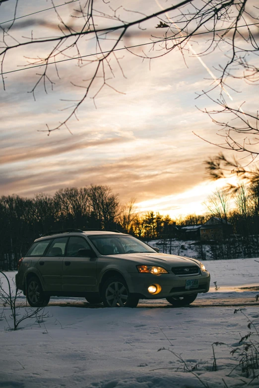a car that is sitting in the snow, by Andrew Stevovich, pexels contest winner, sunset evening lighting, late 2000’s, subaru, brown