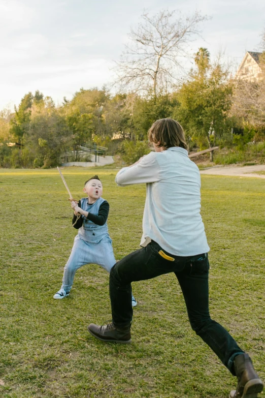 a woman and a child playing baseball in a field, an album cover, unsplash, happening, sword fight, kung fu, bo burnham, tourist photo