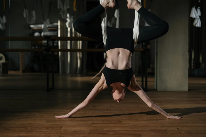 a woman doing a handstand on a wooden floor, pexels contest winner, arabesque, avatar image, harnesses and garters, sweat flying, thumbnail