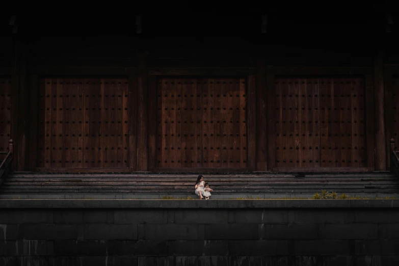 a woman sitting on a ledge in front of a building, a picture, by Torii Kiyomasu, unsplash contest winner, minimalism, little girl, 15081959 21121991 01012000 4k, very dark background, japonisme 3 d 8 k ultra detailed