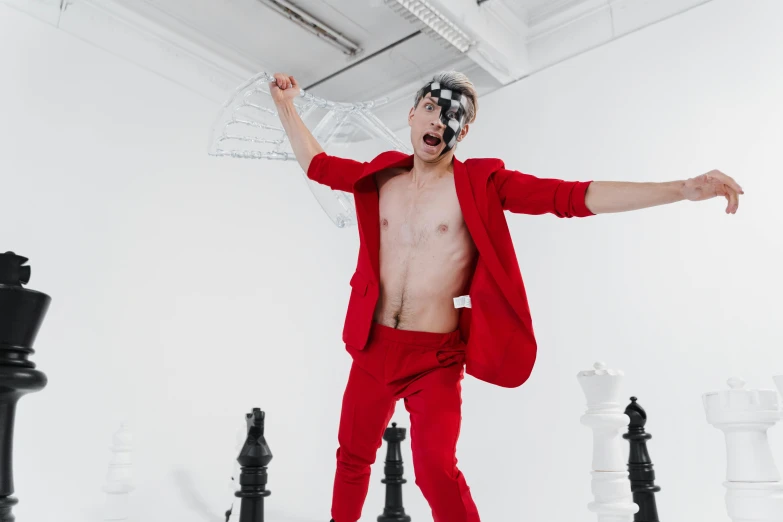 a man standing on top of a chess board, an album cover, by Emma Andijewska, pexels contest winner, de stijl, red body suit, excitement, youtube thumbnail, wearing a crown and suit