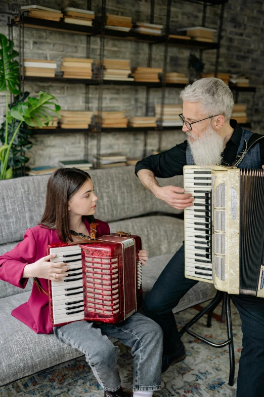 a man playing an accordion next to a woman sitting on a couch, pexels contest winner, old gigachad with grey beard, with a kid, nerdy music teacher with phd, promotional image