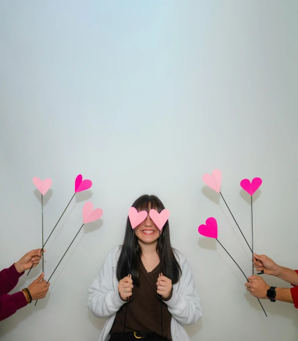 a group of people holding up paper hearts, by Valentine Hugo, pexels contest winner, aestheticism, asian girl, ((pink)), three heads, minimalist ) ) ) ) )