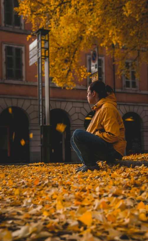 a man sitting on the ground in front of a building, by Sebastian Spreng, pexels contest winner, golden leaves, 15081959 21121991 01012000 4k, yellow sky, profile picture 1024px