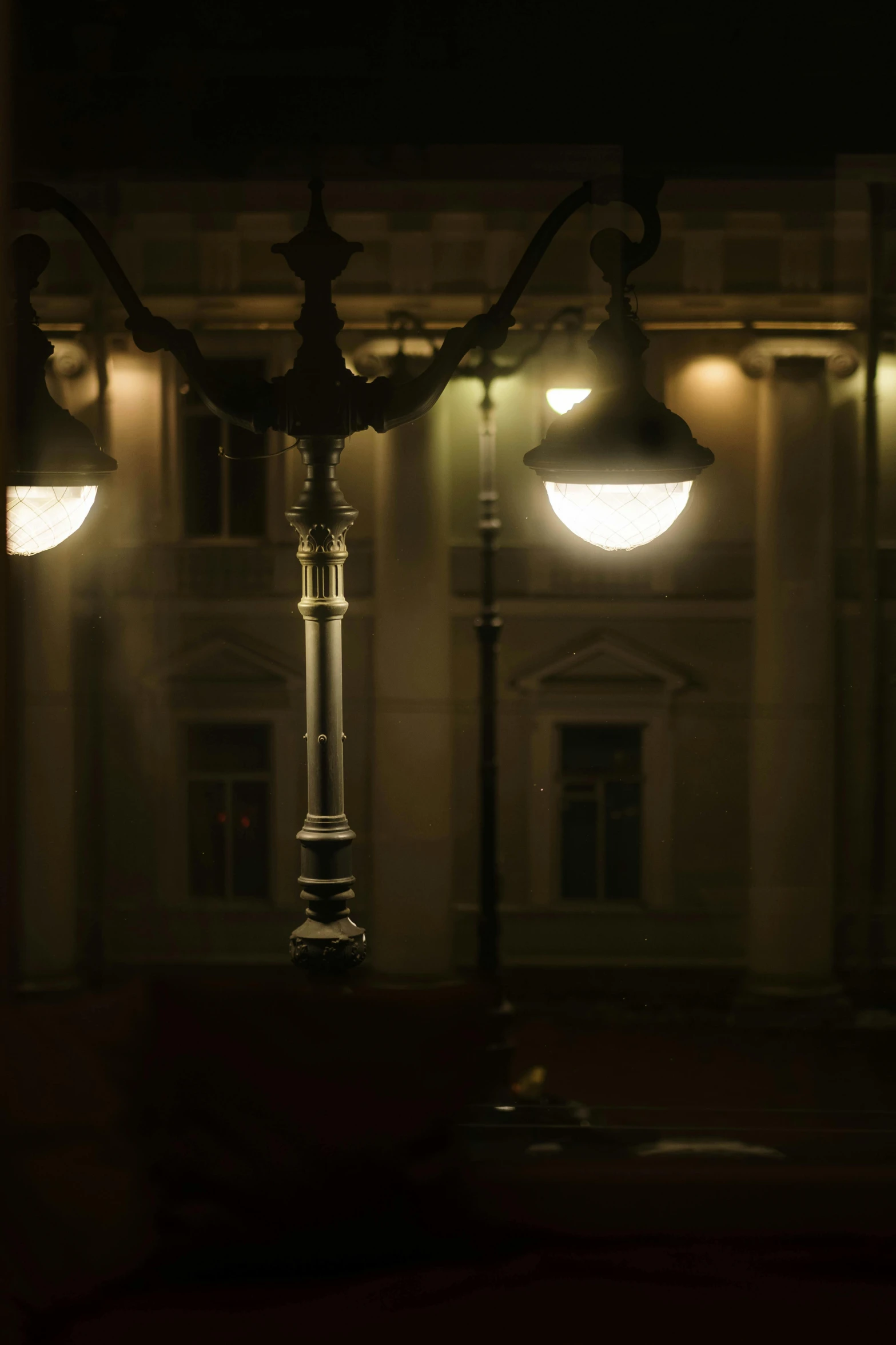 a street light in front of a building at night, inspired by Mihály Munkácsy, columns, foreboding room, dramatic lighting - n 9, lamps