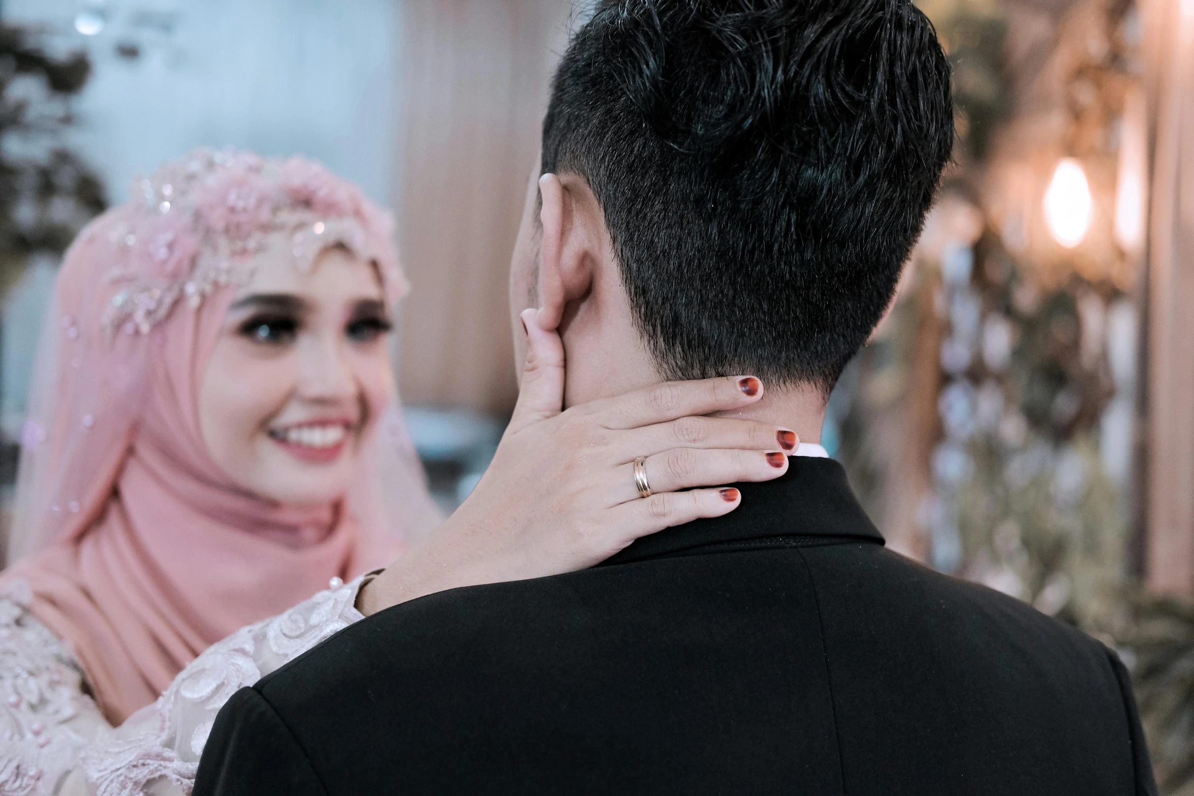 a man in a tuxedo and a woman in a hijab, pexels contest winner, hurufiyya, sitting on man's fingertip, white and pink cloth, thumbnail, wearing jewellery