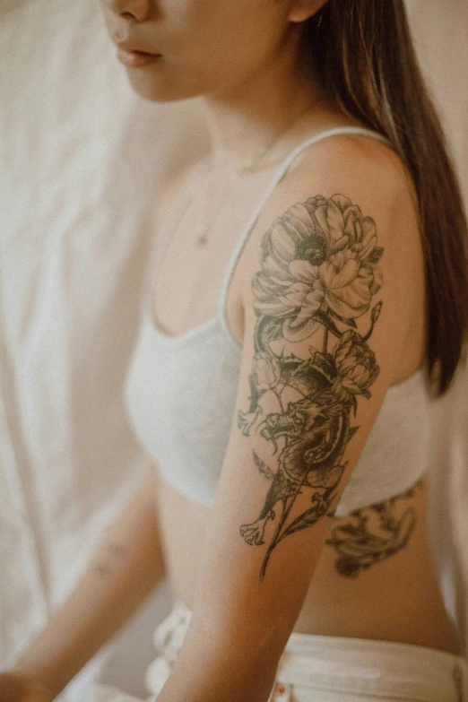 a woman with a tattoo on her arm, top half of body, varying detailed skin, smooth body features, soft outlines