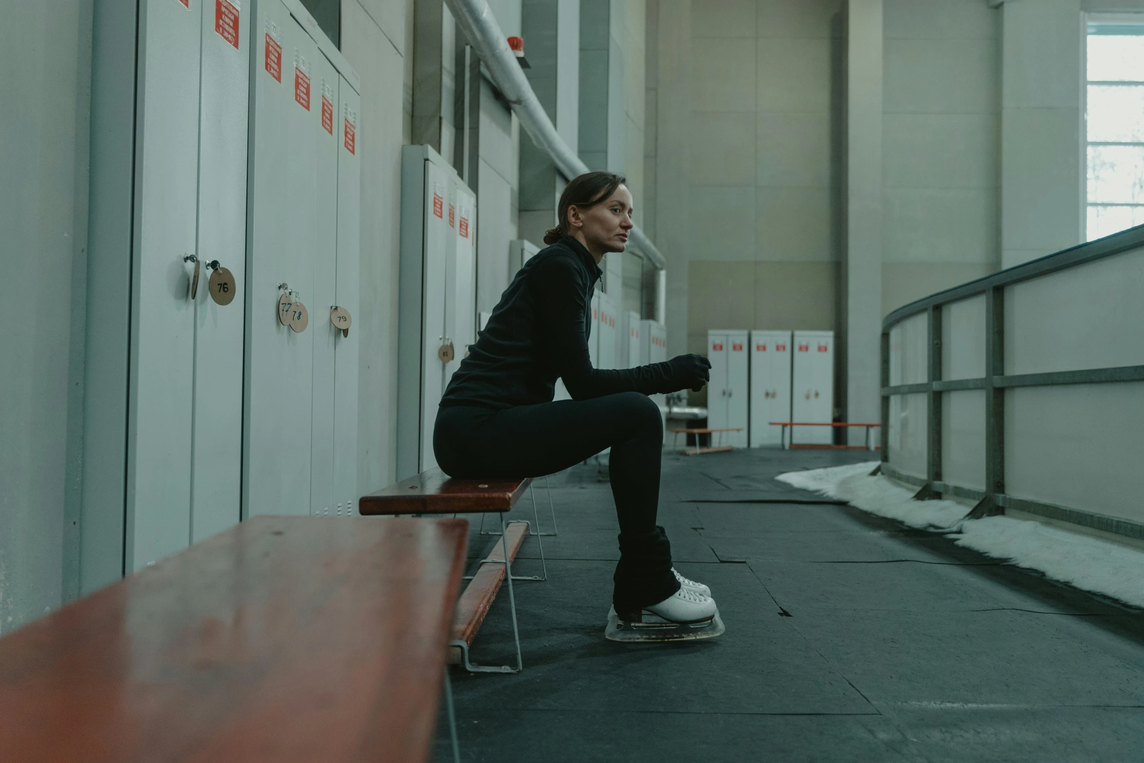 a woman sitting on top of a wooden bench, by Emma Andijewska, dynamic skating, low quality photo, stood in a cell, sweat