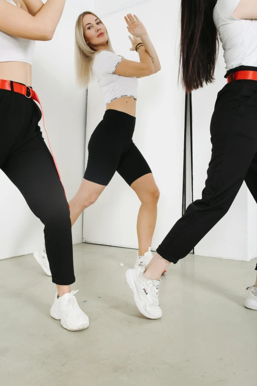 a group of young women dancing in a dance studio, an album cover, by Matija Jama, trending on pexels, antipodeans, sport pants, black red white clothes, 3 - piece, detail shot