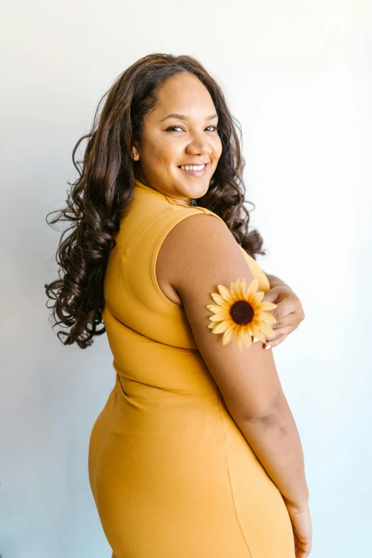 a woman in a yellow dress posing for a picture, light brown skin, sunflower, full figured, promo image