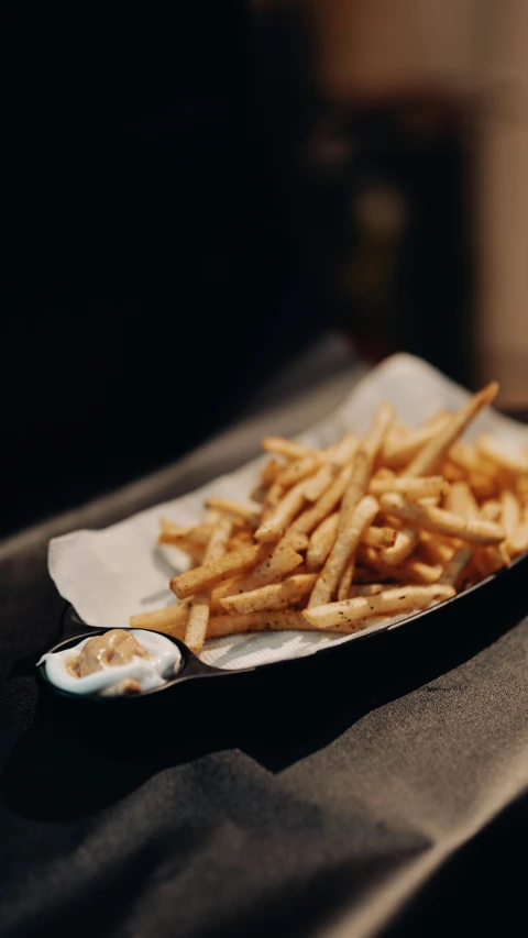 a plate of french fries on a table, inspired by Pia Fries, pexels, renaissance, with a black background, fancy dressing, thumbnail, white