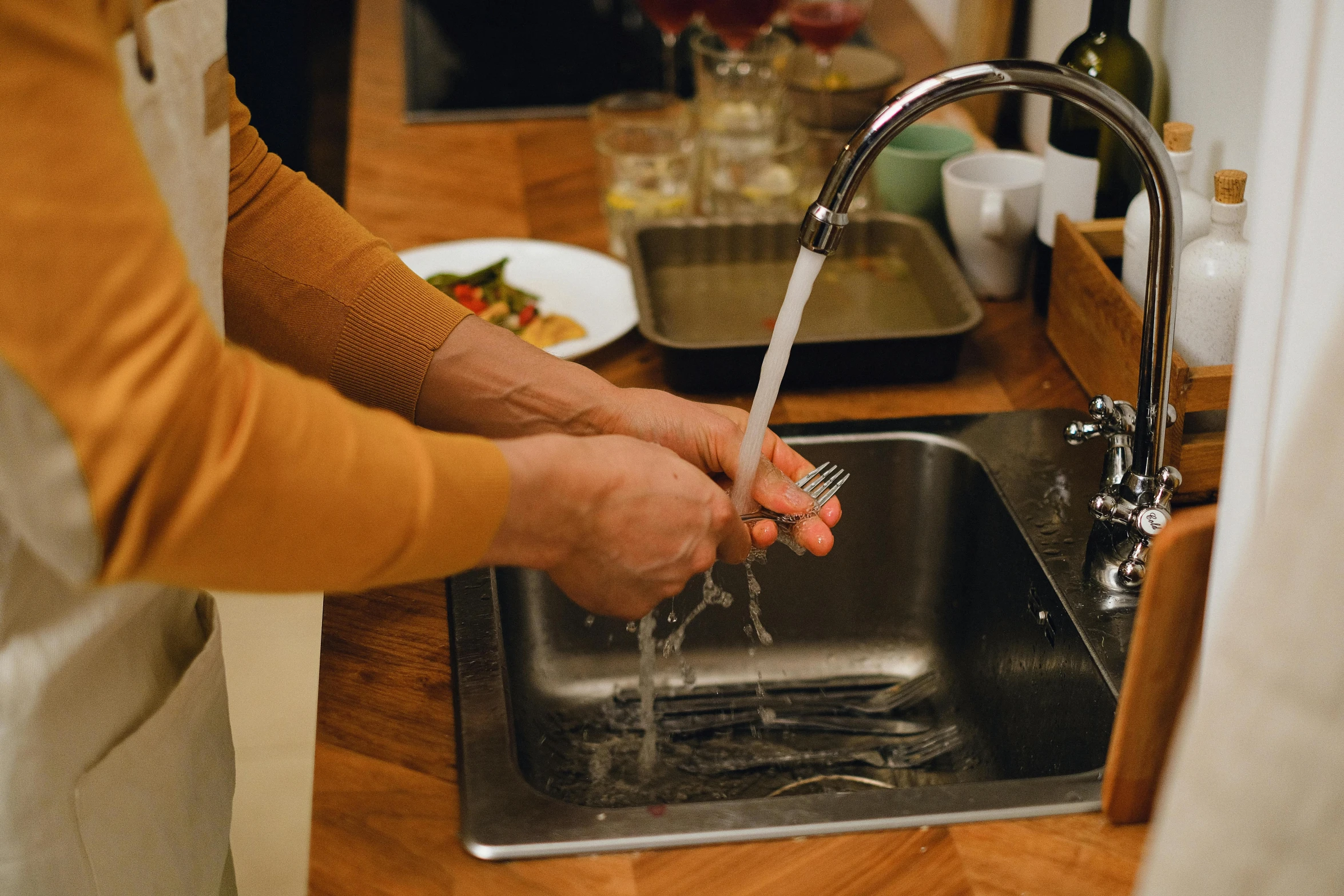 a person washing their hands in a kitchen sink, pexels contest winner, plating, full-body, churning, mid riff