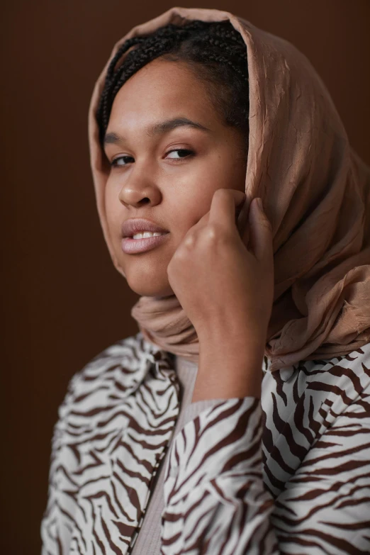 a woman in a zebra print jacket talking on a cell phone, an album cover, hurufiyya, muted brown, head scarf, 2022 photograph, mixed race woman