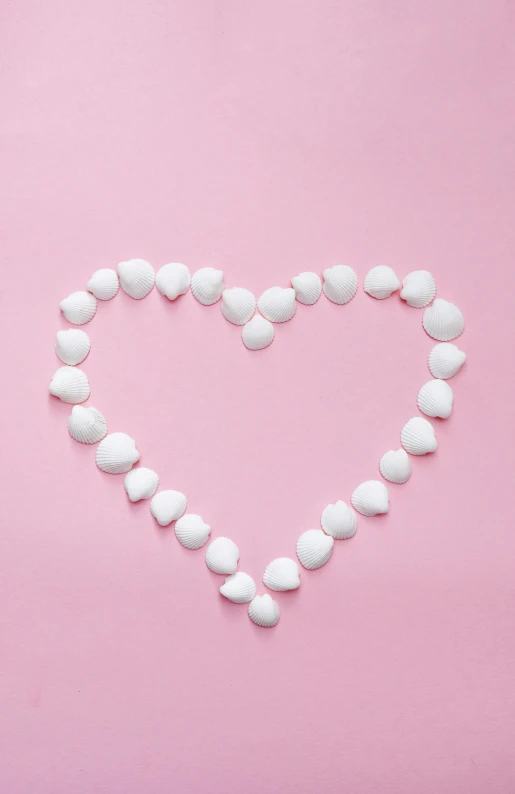 a heart made out of white pebbles on a pink background, pexels, candy decorations, jen atkin, 12, long