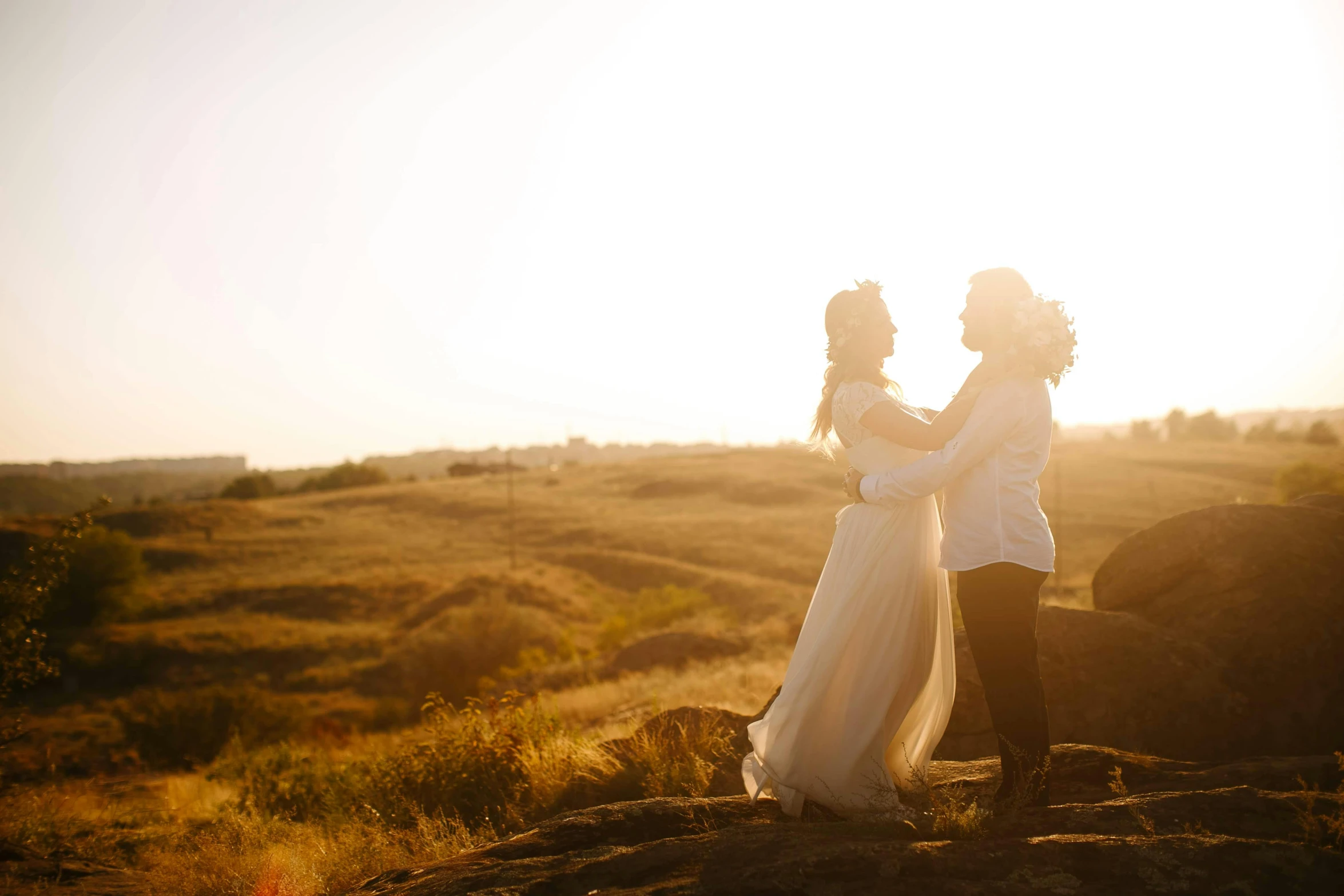 a man and a woman standing next to each other in a field, unsplash, romanticism, on a rock, avatar image, wedding photo, goldenhour