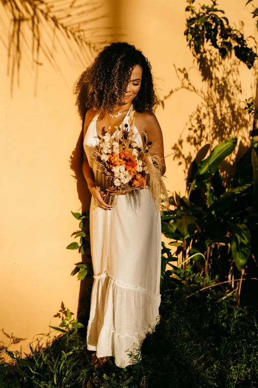 a woman in a white dress holding a bouquet, golden hour hues, jungle gown, sunny complementary palette, shades of gold display naturally