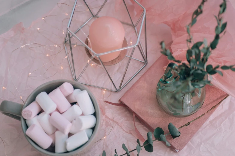 a table topped with a bowl of marshmallows and a candle, by Emma Andijewska, pexels contest winner, aestheticism, light pink mist, candy decorations, wrapped in wires and piones, trending on vsco