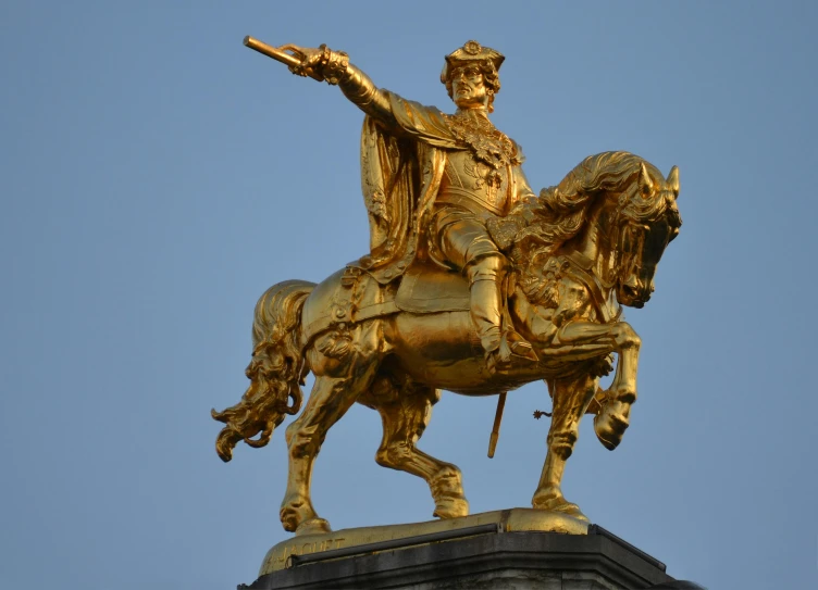 a golden statue of a man on a horse, inspired by Prince Hoare, baroque, on his right hand, in the evening