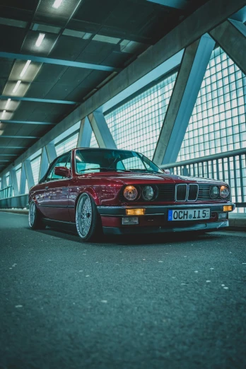 a red car parked on the side of a road, a picture, by Carlo Martini, pexels contest winner, renaissance, bmw e 3 0, low ceiling, portrait of jerma985, indoor picture
