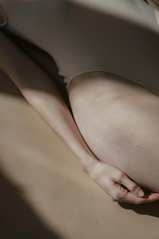 a pregnant woman in a white bodysuit laying on the floor, inspired by Vanessa Beecroft, unsplash, close-up of thin soft hand, her skin is light brown, ignant, illustration »