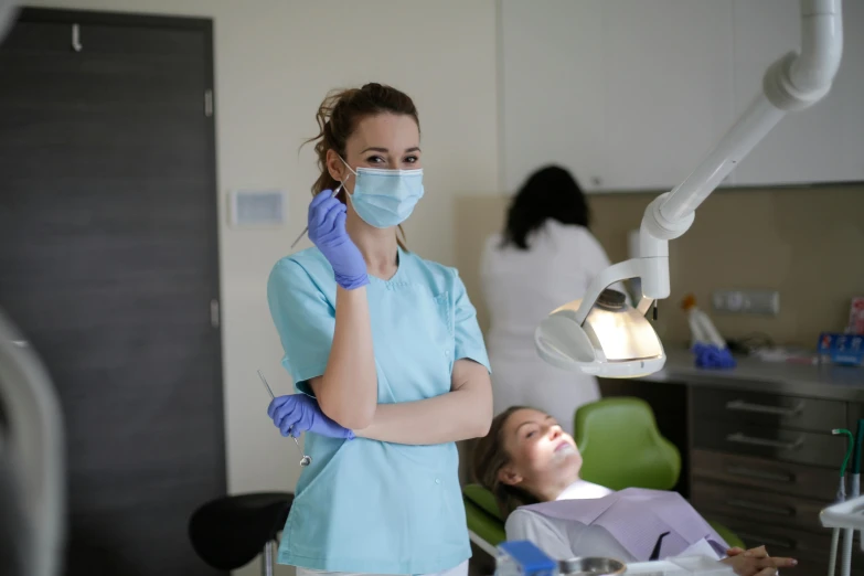 a woman sitting in a chair in a dentist's chair, by Adam Marczyński, pexels contest winner, hurufiyya, avatar image, surgical gown and scrubs on, school class, thumbnail