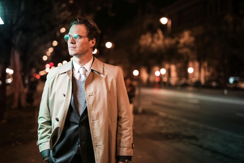 a man standing on a city street at night, a portrait, unsplash, bauhaus, light brown coat, steve buscemi with sunglass, teal suit, dressed in an old white coat