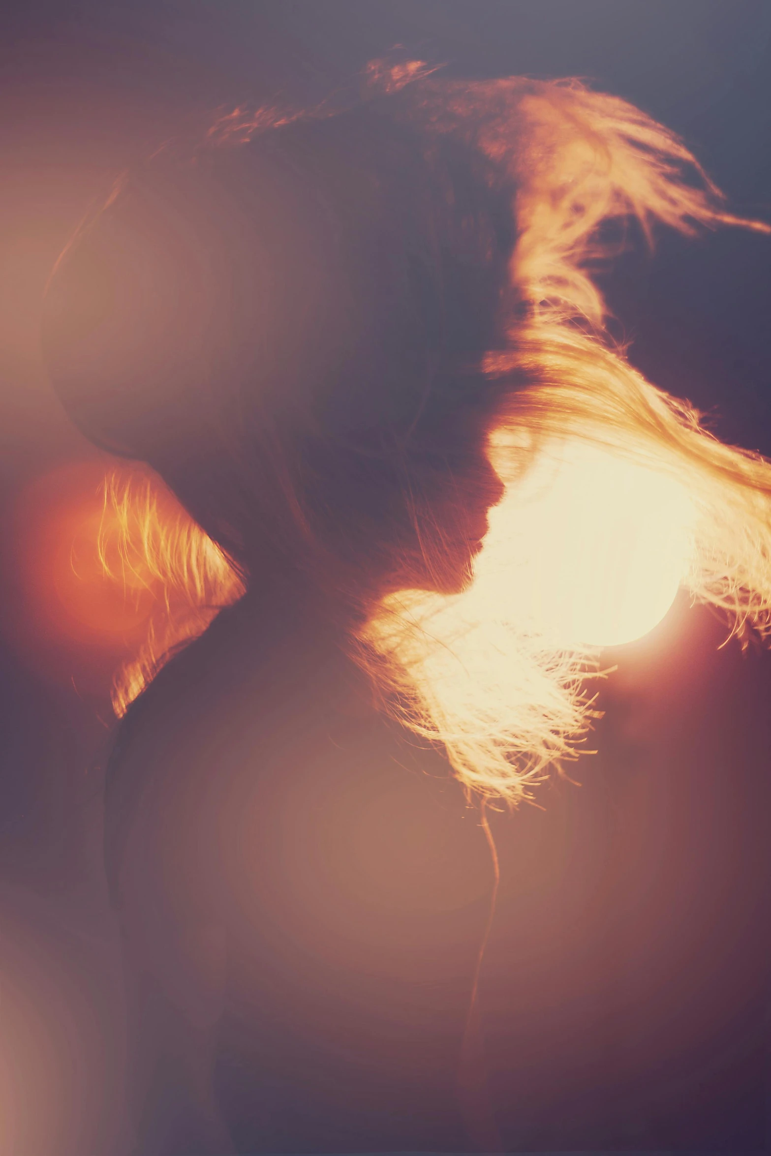 a woman with her hair blowing in the wind, inspired by Elsa Bleda, light and space, on fire, back - lit, grainy, close up of a blonde woman