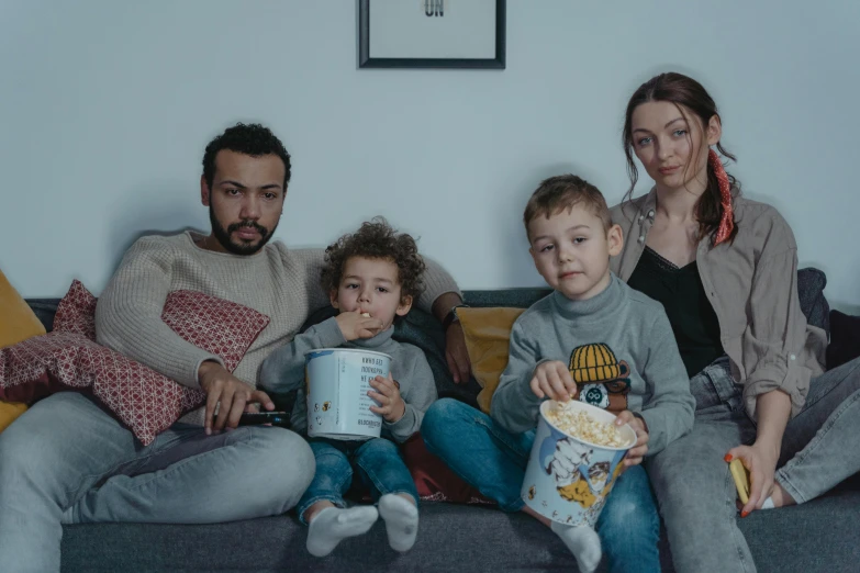 a group of people sitting on top of a couch, a cartoon, pexels, les nabis, husband wife and son, quality cinema model, romanian, very realistic cinematic