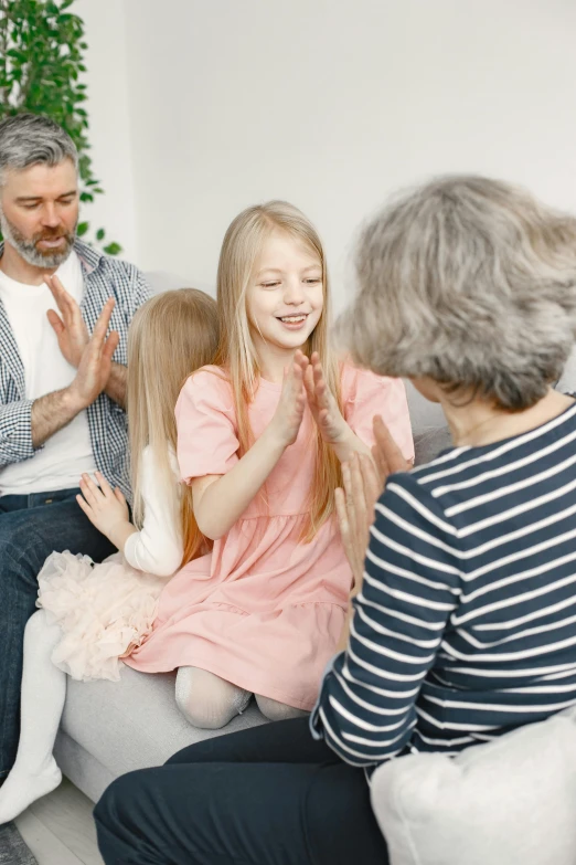 a group of people sitting on top of a couch, with a kid, blessing hands, calmly conversing 8k, high-quality photo