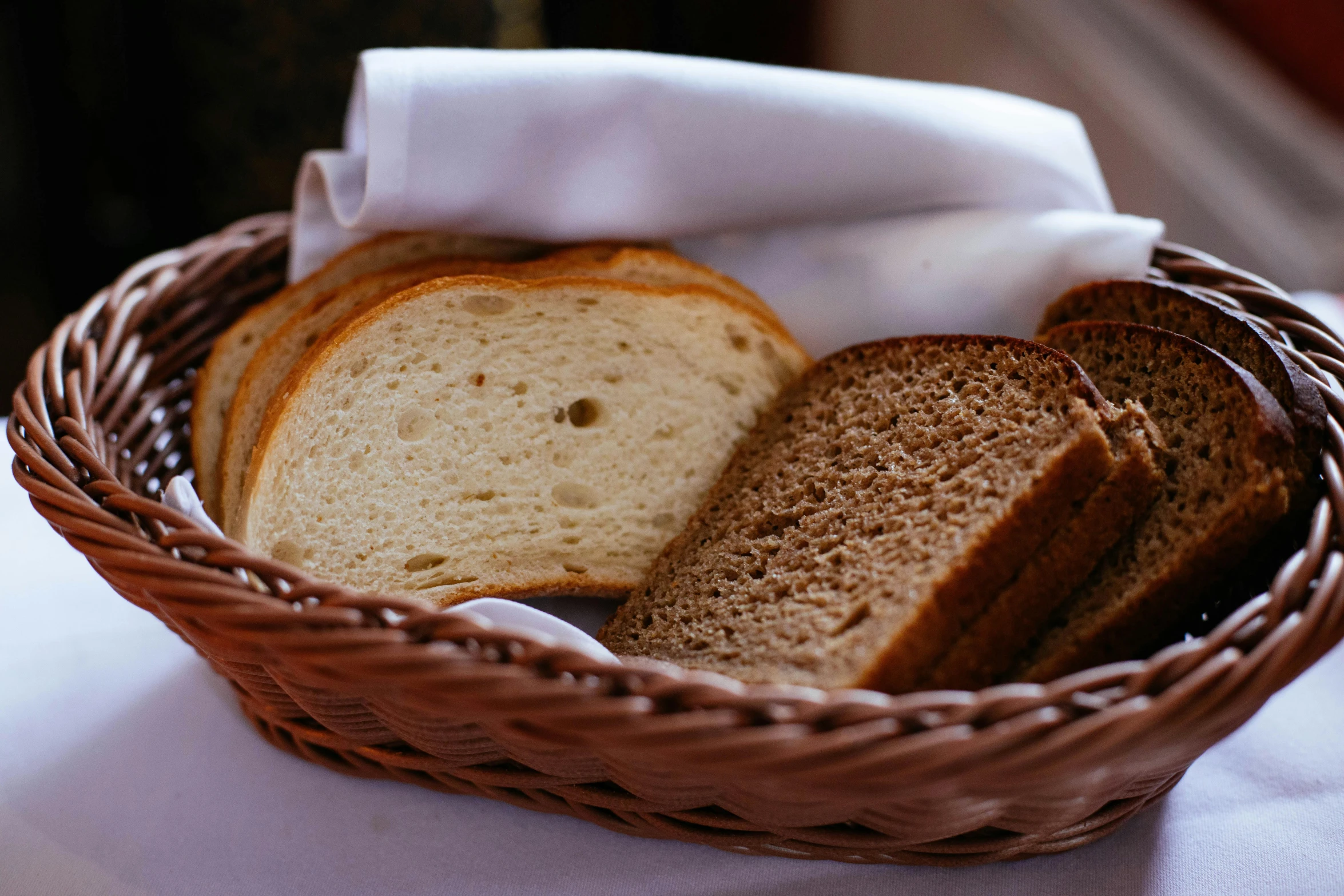 a basket of bread sitting on top of a table, light tan, toast, food, uncrop