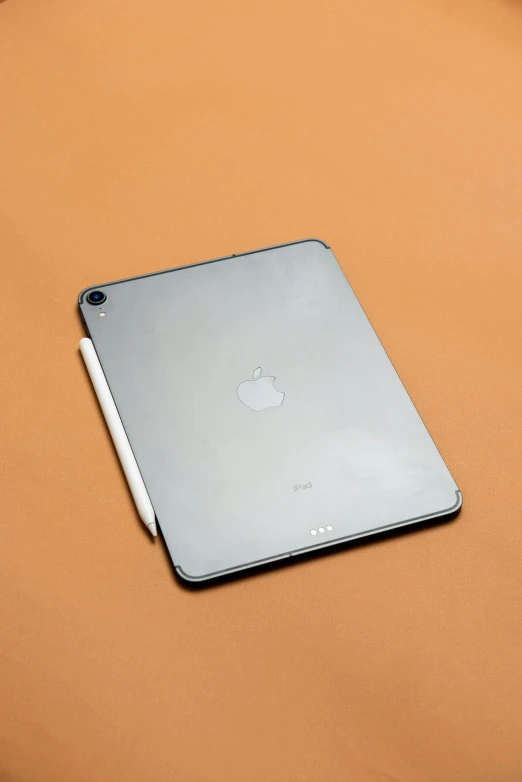 an apple ipad sitting on top of a bed, a digital rendering, by Carey Morris, unsplash, photorealism, 2 5 6 x 2 5 6, skin reflective metallic, plain background, chrome silver