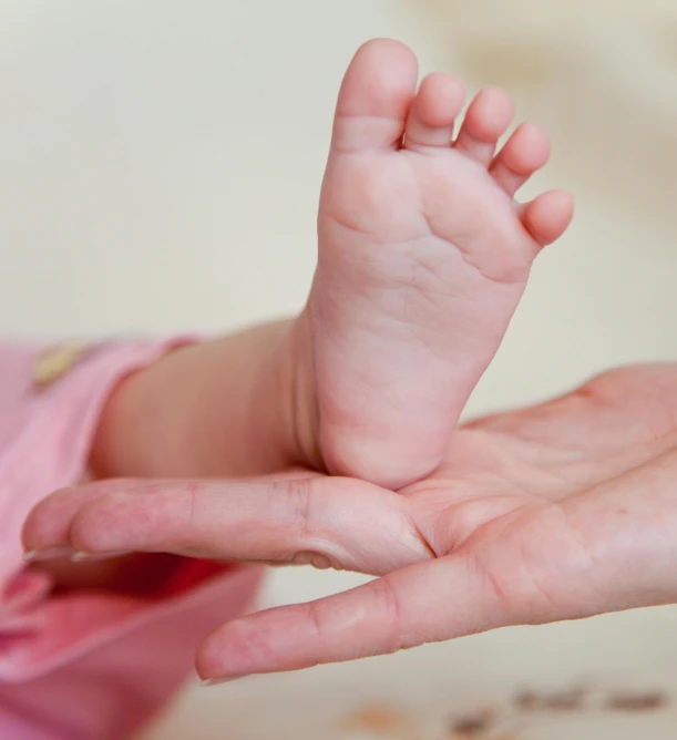 a close up of a person holding a baby's foot, incoherents, square, 2263539546], bump in form of hand, thumbnail