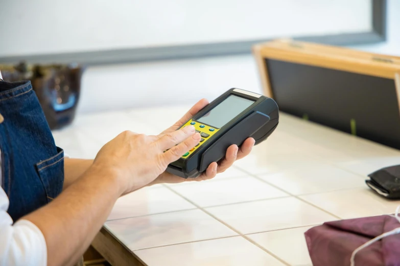 a person using a pos terminal on a counter, by Matthias Stom, scan lines, hi - res scan, fan favorite, mathematical