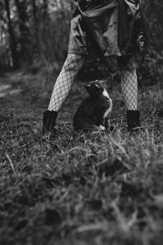 a black and white photo of a person and a cat, unsplash, conceptual art, plaid tights, forest fae, pets, fishnet